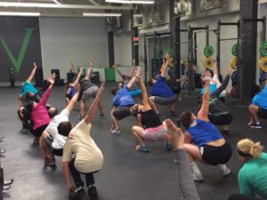 A group fitness class does a stretch in unison.