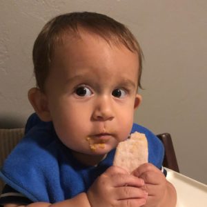 Cute Invictus baby looking guilty after snatching cookie from the cookie jar.