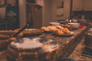 Kitchen counter lined with many different serving platters of delicious looking food.