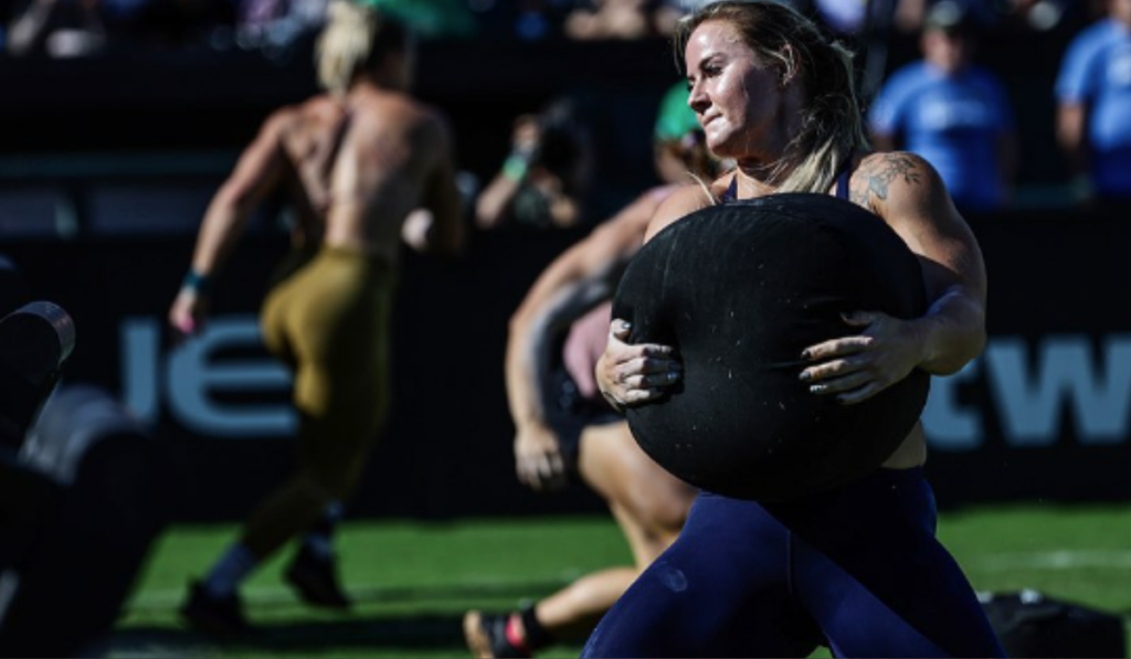 Invictus Athlete Dani Speegle lifts a sandbag with ease at the 2023 Rogue Invitational.