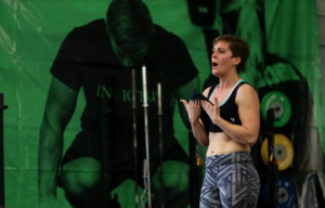 Female athlete wiping away sweat with her shirt.